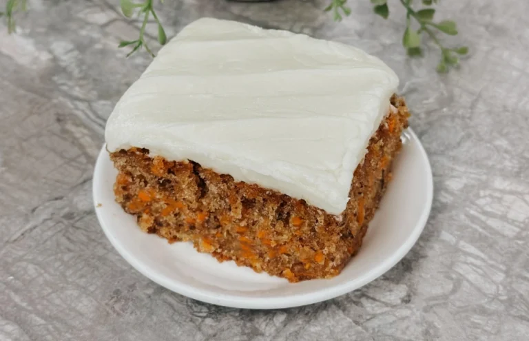 Classic carrot cake with cream cheese frosting and a slice showing the moist orange crumb