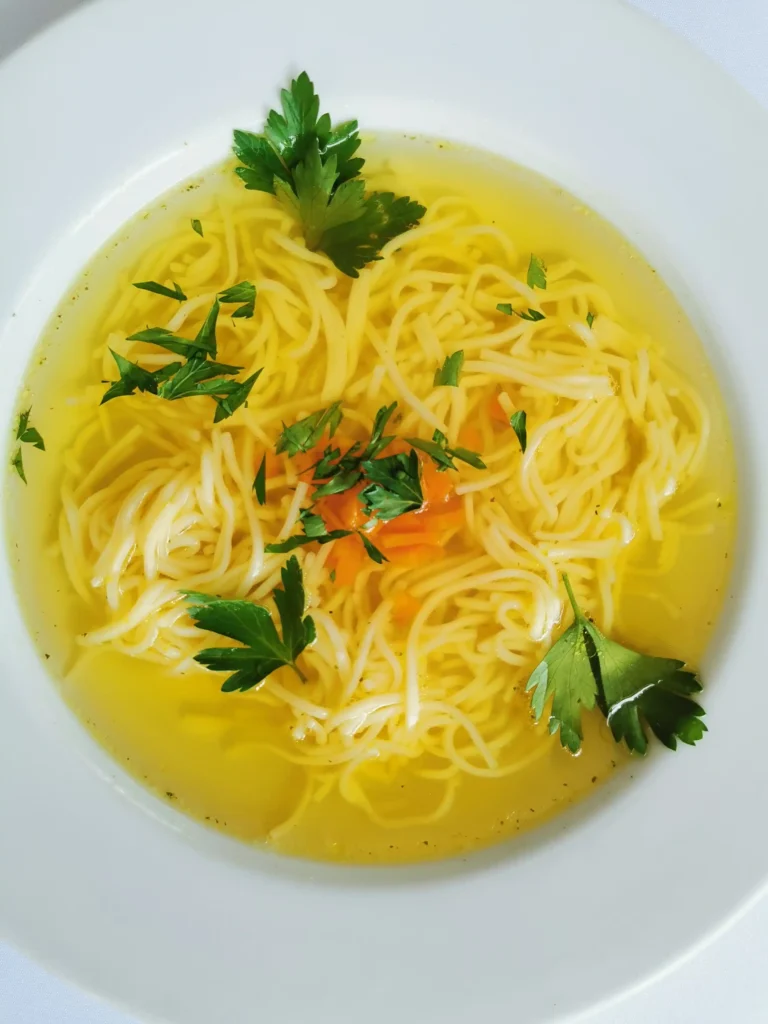Homemade chicken noodle soup with egg noodles, vegetables and clear golden broth