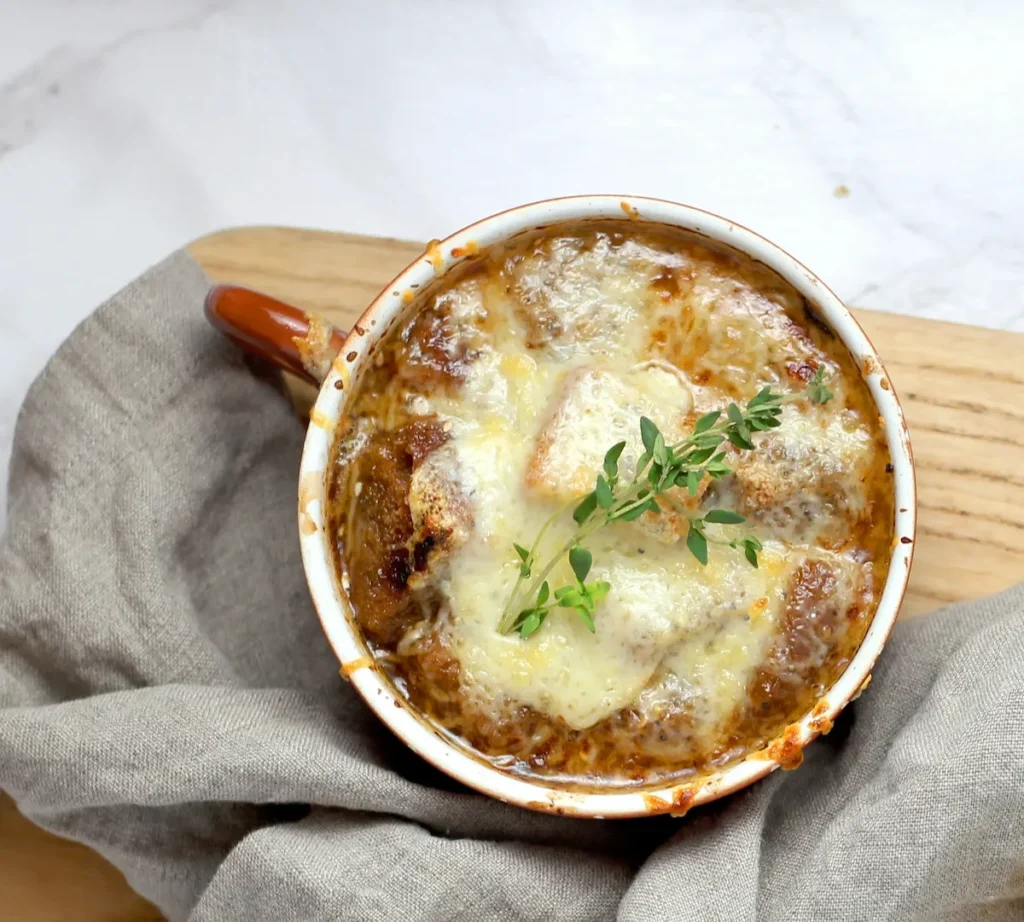 Classic French onion soup in a crock with melted Gruyere cheese on top