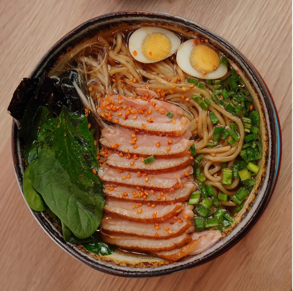 Japanese ramen bowl with soft-boiled egg, chashu pork and noodles in broth