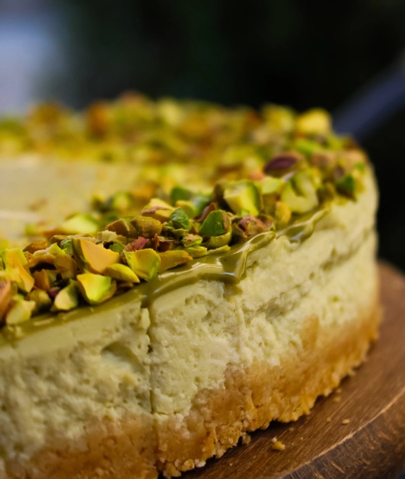 Moist pistachio cake slice showing the green pistachio-flecked crumb