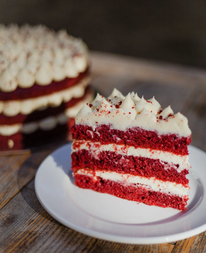 Classic red velvet cake slice showing the deep red crumb and white cream cheese frosting