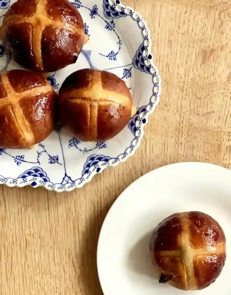 Soft fluffy hot cross buns in a tray with white crosses on top