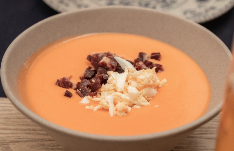 Spanish Salmorejo cold tomato soup, topped with diced jamón serrano and crumbled hard-boiled egg