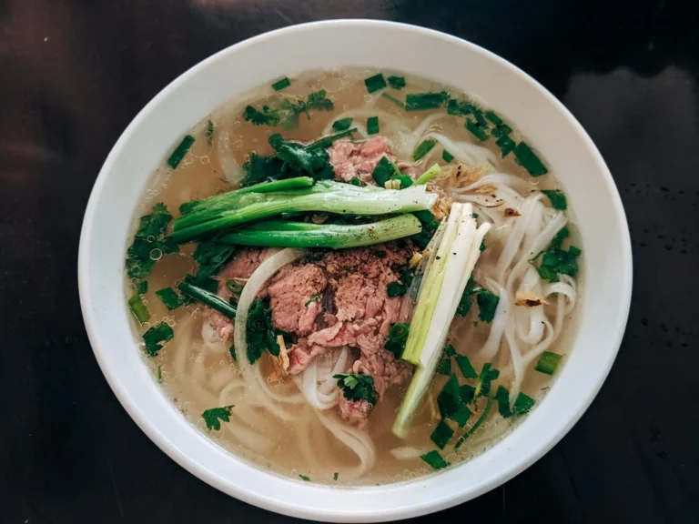 Vietnamese beef pho bowl with thin beef slices, rice noodles and fresh herbs